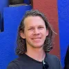 Jeff Carbine in a suit coat against a brick wall