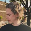 Jeff Carbine in a suit coat against a brick wall