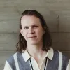 Jeff Carbine in a suit coat against a brick wall