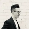 Jeff Carbine in a suit coat against a brick wall